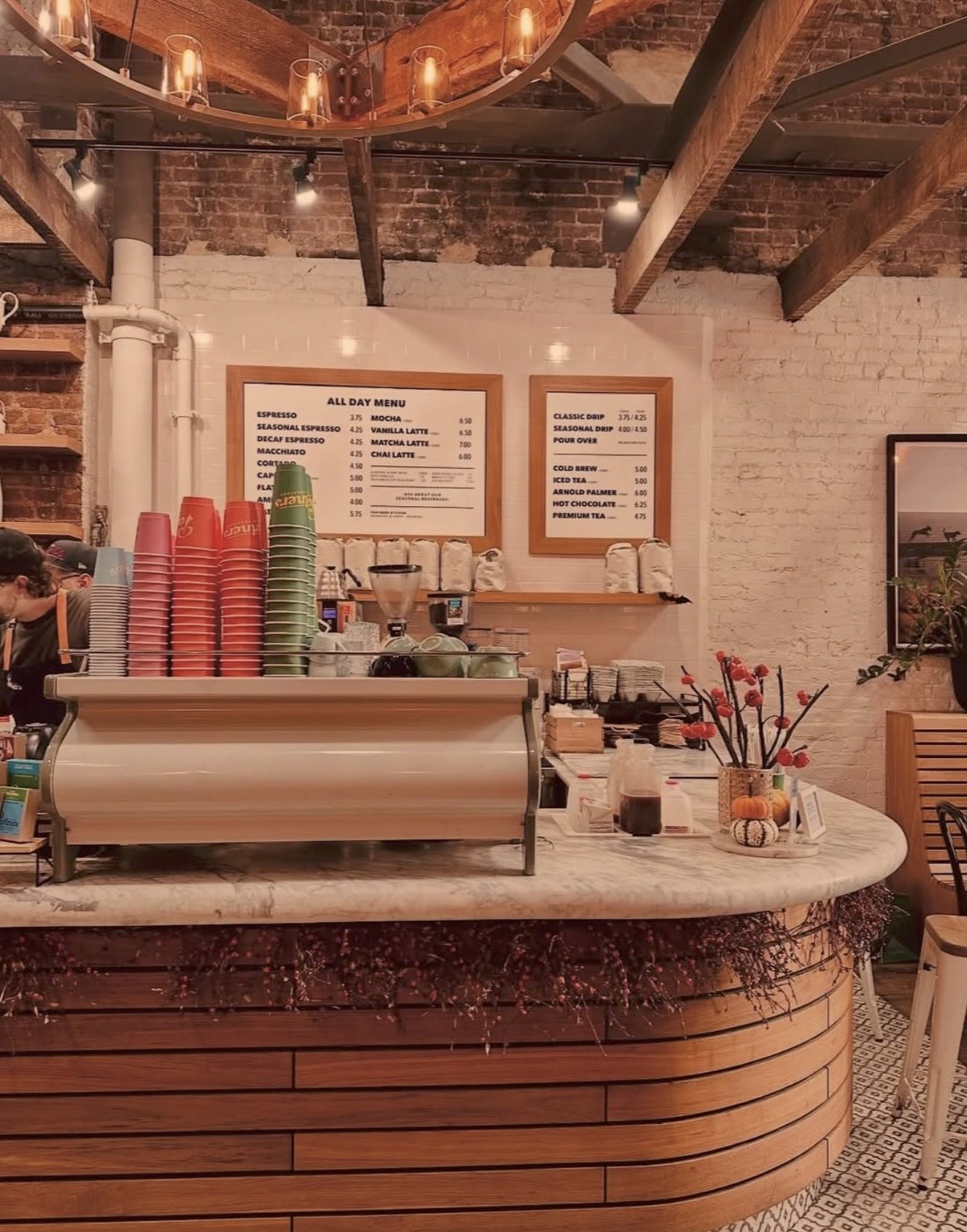The curved wood espresso counter at Partners Coffee with menu boards and retail bean bags behind